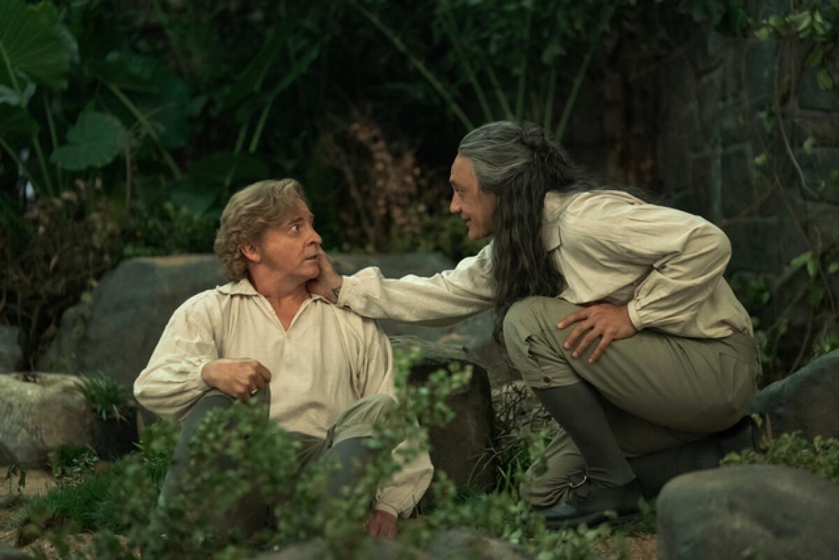 A man lovingly holds another man's cheek.