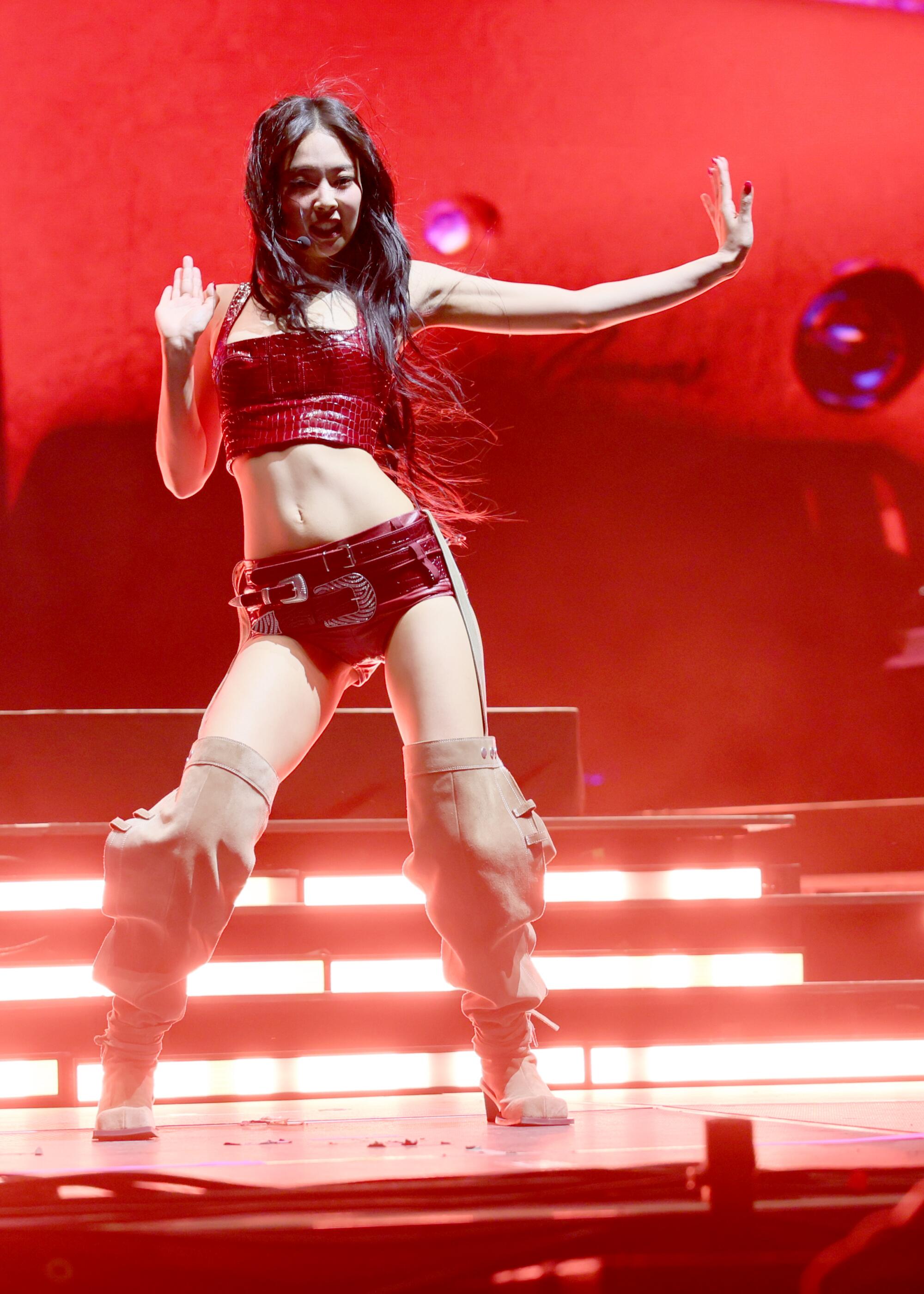 Jennie performing and holding her hands out