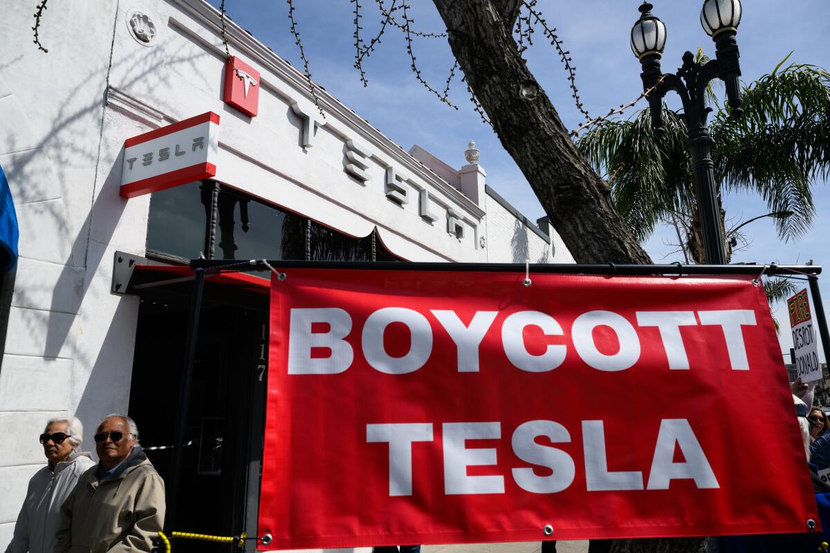 A sign stating "Boycott Tesla" during a protest.
