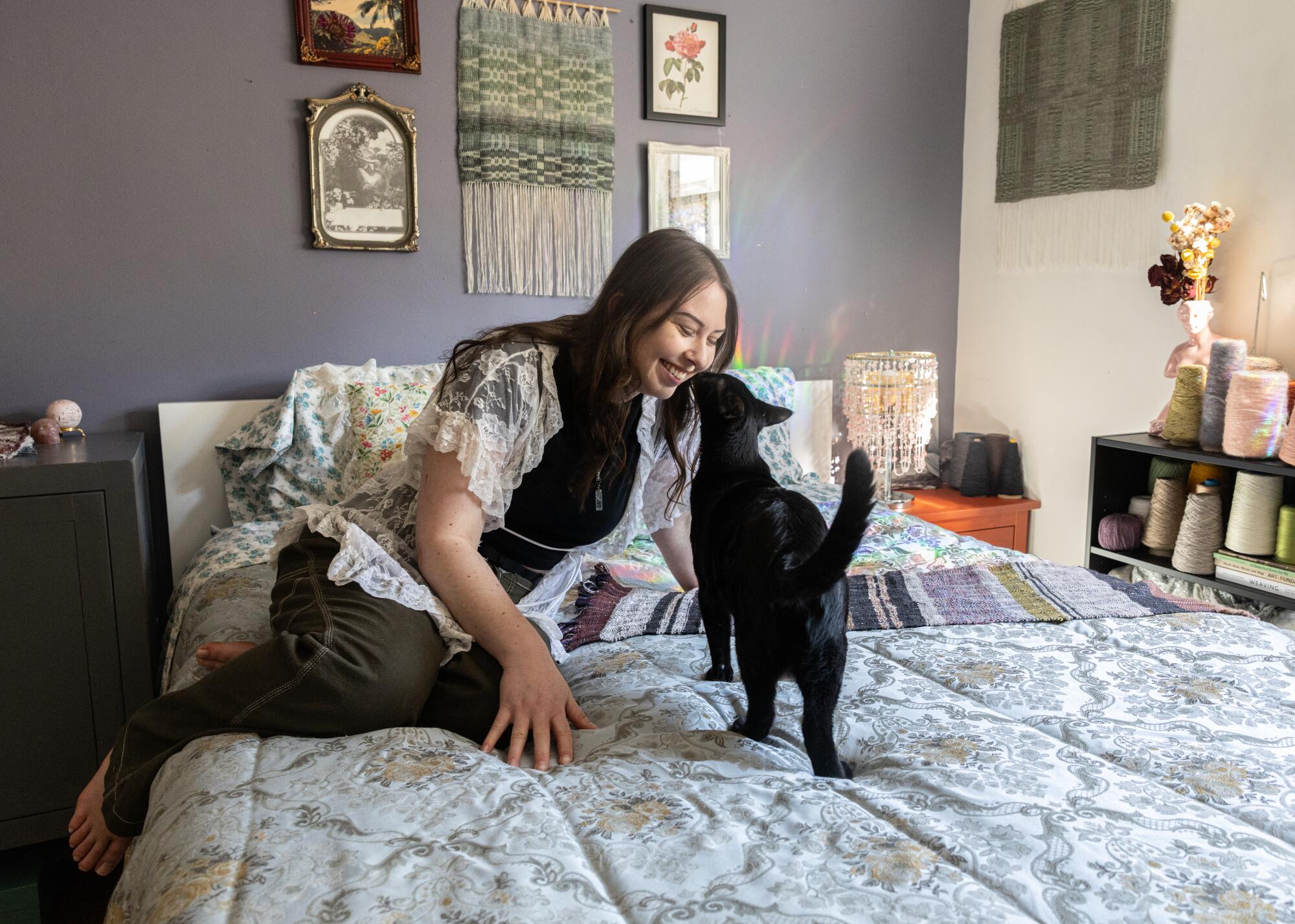 Fiona Simpson and her cat, Milo, exchange a nose kiss in her bedroom studio.