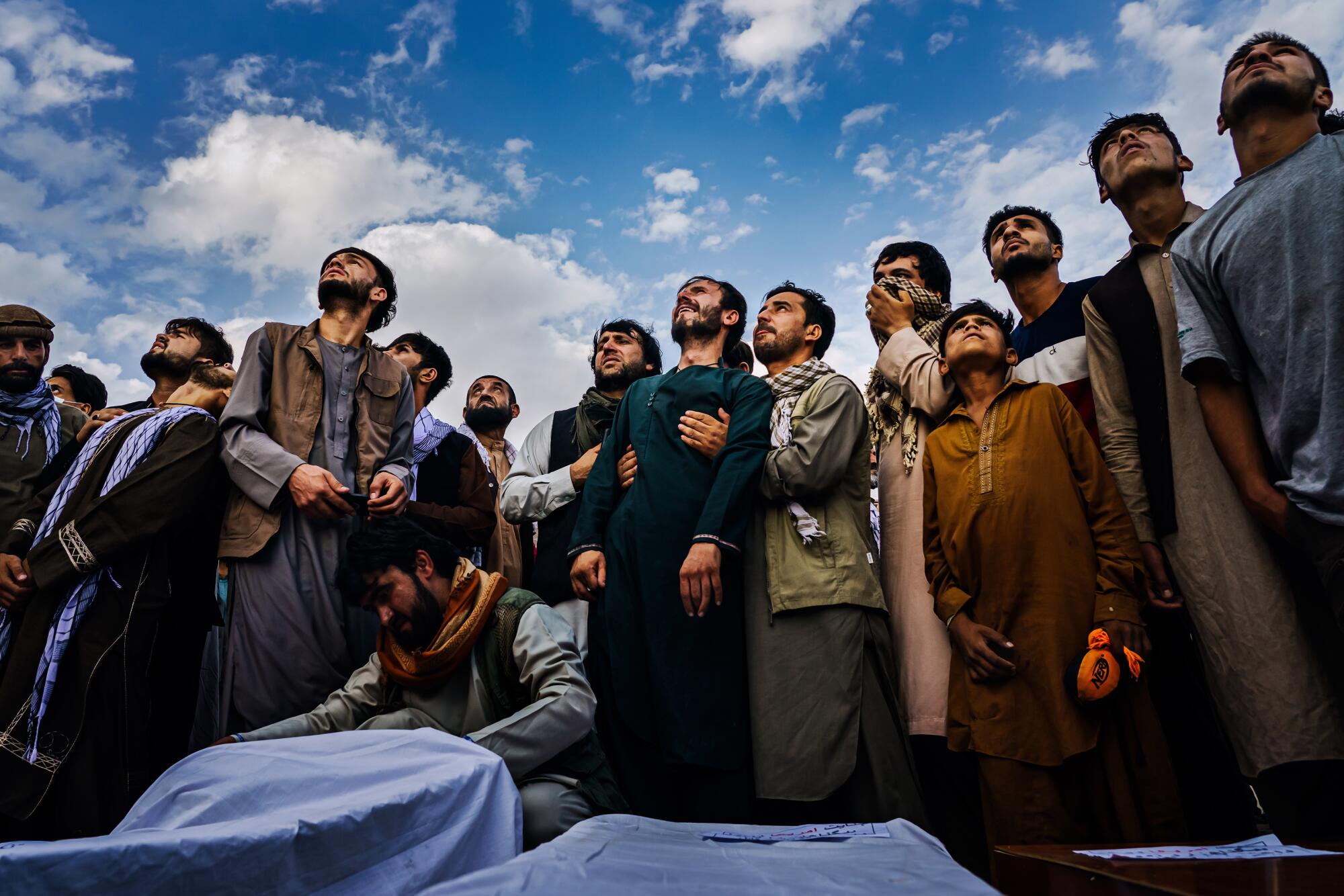 Mourners look to the sky.