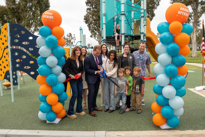 Mayor Joe Stapleton and Alexis Portillo cut the ribbon to the newly renovated playground at San Miguel Park.