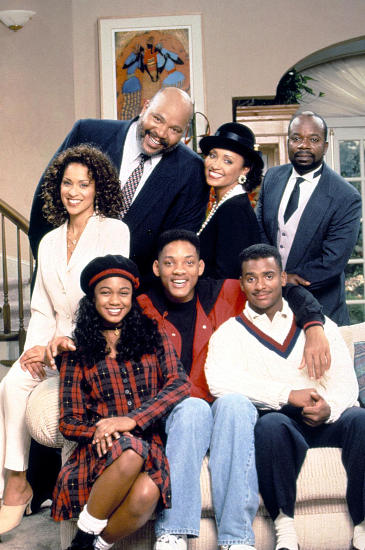 Seven people pose for a family portrait in a room.